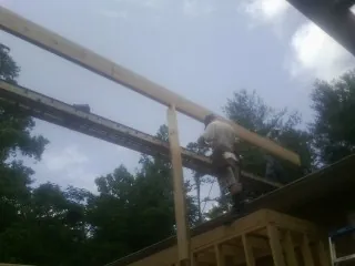 Carpenter setting a ridge beam over a new addition frame — Ice Dam Removal by Roofing Brothers in Shady Cove