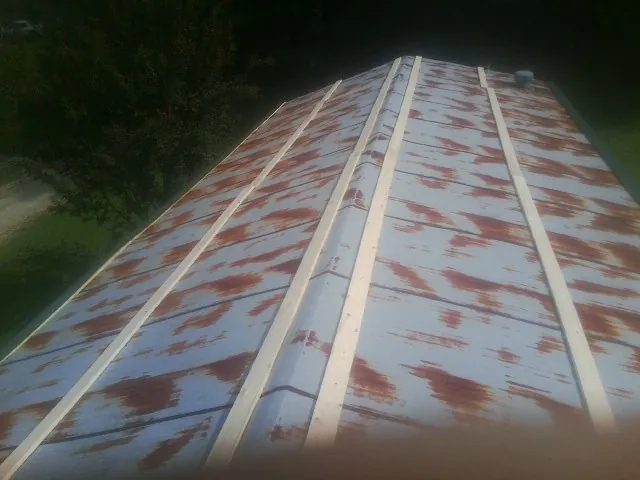 Rusted metal roof panels with new wood purlins before replacement — Storm Damage Roof Repair in Shady Cove by Roofing Brothers