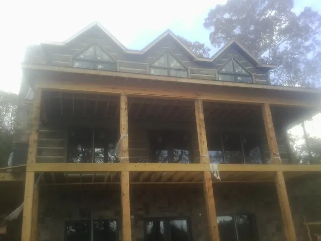 Dormers and porch framing on a large log home under construction — Roof Coating work by our crew in Shady Cove