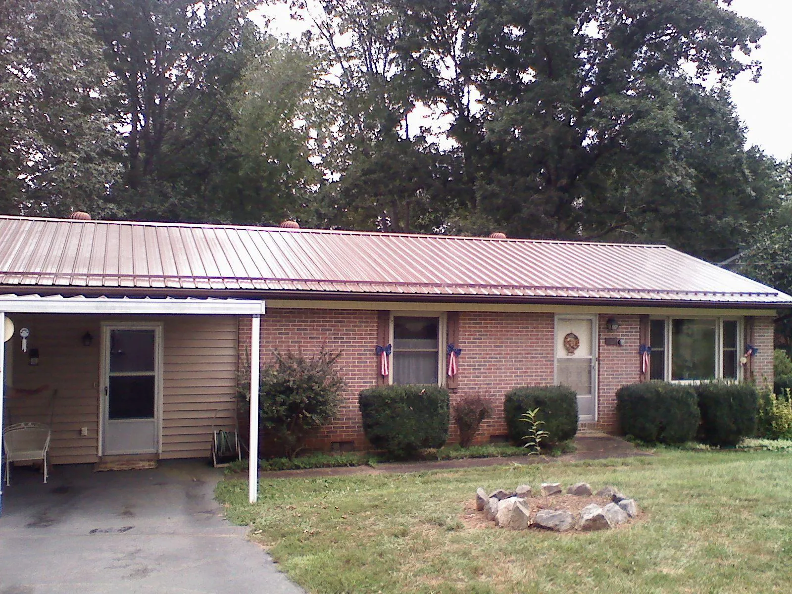 Bronze metal roof and carport on a brick ranch home — Roof Repair work by our crew in Shady Cove